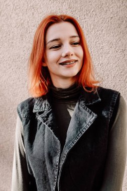 Gülümseyen Kızıl Saçlı Diş telleriyle Kış Giysilerinde Poz Veren Genç Kız