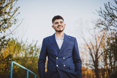 Mavi Takım Elbiseli Genç Adam Parkta Emin Bir Poz Veriyor