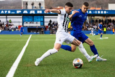 SURDULICA, SERBIA, 12 Mart 2025: FK Partizan ve FK Radnik oyuncuları Gradski Stadyumu 'ndaki Sırbistan SuperLiga futbol karşılaşması sırasında top için mücadele ediyorlar.
