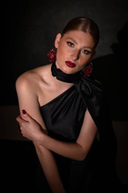 Siyah saten elbiseli özgüvenli genç bir kadının orta boy stüdyo resmi balo gecesi için hazır..