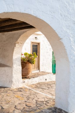 Geleneksel Akdeniz mimarisi beyaz kemerli, terakotta tencereli ve ahşap kapılı.