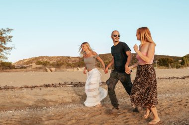 Mutlu çift gün batımında Potos, Thassos 'ta plajda koşuyor.