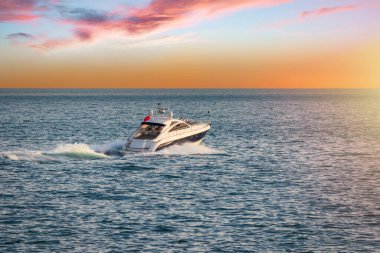Luxury motor yacht on the ocean at sunset in Bournemouth England
