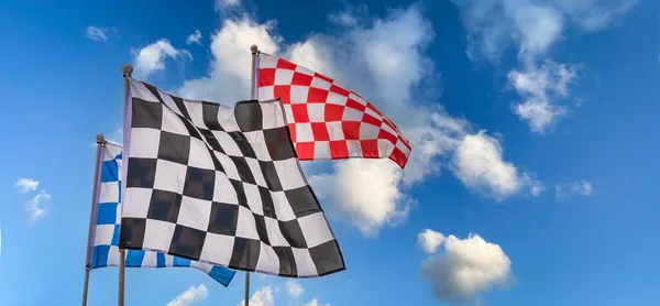 Black, white, red and blue Checkered Flags on a sky blue background