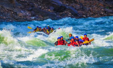 İnsanlar Rishikesh Hindistan 'da Ganj nehrinde rafting yaparken eğleniyorlar.