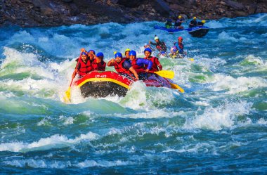 İnsanlar Rishikesh Hindistan 'da Ganj nehrinde rafting yaparken eğleniyorlar.
