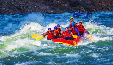 İnsanlar Rishikesh Hindistan 'da Ganj nehrinde rafting yaparken eğleniyorlar.