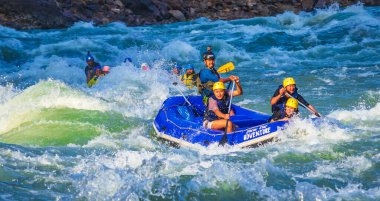 İnsanlar Rishikesh Hindistan 'da Ganj nehrinde rafting yaparken eğleniyorlar.