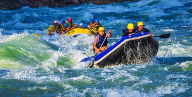 İnsanlar Rishikesh Hindistan 'da Ganj nehrinde rafting yaparken eğleniyorlar.
