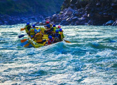 İnsanlar Rishikesh Hindistan 'da Ganj nehrinde rafting yaparken eğleniyorlar.