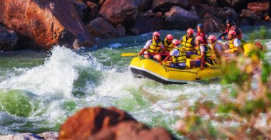 İnsanlar Rishikesh Hindistan 'da Ganj nehrinde rafting yaparken eğleniyorlar.