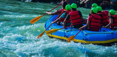İnsanlar Rishikesh Hindistan 'da Ganj nehrinde rafting yaparken eğleniyorlar.