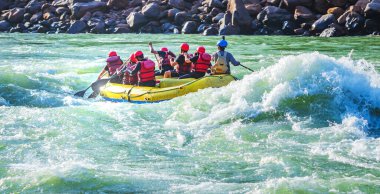 İnsanlar Rishikesh Hindistan 'da Ganj nehrinde rafting yaparken eğleniyorlar.