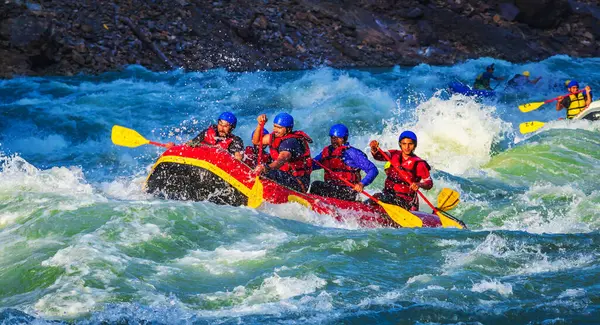 İnsanlar Rishikesh Hindistan 'da Ganj nehrinde rafting yaparken eğleniyorlar.