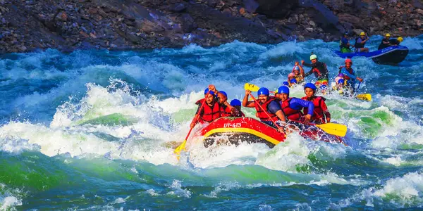 İnsanlar Rishikesh Hindistan 'da Ganj nehrinde rafting yaparken eğleniyorlar.