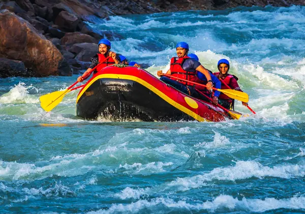 İnsanlar Rishikesh Hindistan 'da Ganj nehrinde rafting yaparken eğleniyorlar.