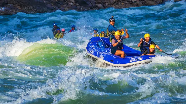 İnsanlar Rishikesh Hindistan 'da Ganj nehrinde rafting yaparken eğleniyorlar.