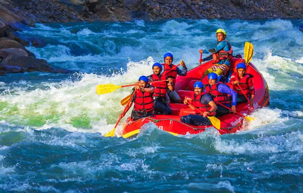 İnsanlar Rishikesh Hindistan 'da Ganj nehrinde rafting yaparken eğleniyorlar.