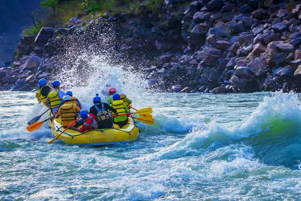 İnsanlar Rishikesh Hindistan 'da Ganj nehrinde rafting yaparken eğleniyorlar.