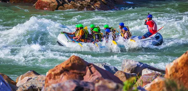 İnsanlar Rishikesh Hindistan 'da Ganj nehrinde rafting yaparken eğleniyorlar.