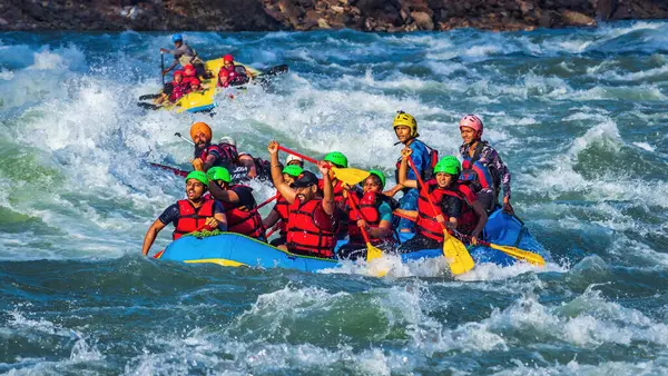 İnsanlar Rishikesh Hindistan 'da Ganj nehrinde rafting yaparken eğleniyorlar.