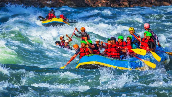 İnsanlar Rishikesh Hindistan 'da Ganj nehrinde rafting yaparken eğleniyorlar.
