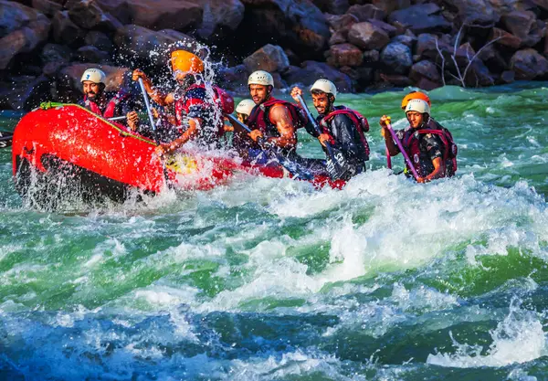 İnsanlar Rishikesh Hindistan 'da Ganj nehrinde rafting yaparken eğleniyorlar.