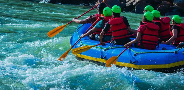 İnsanlar Rishikesh Hindistan 'da Ganj nehrinde rafting yaparken eğleniyorlar.