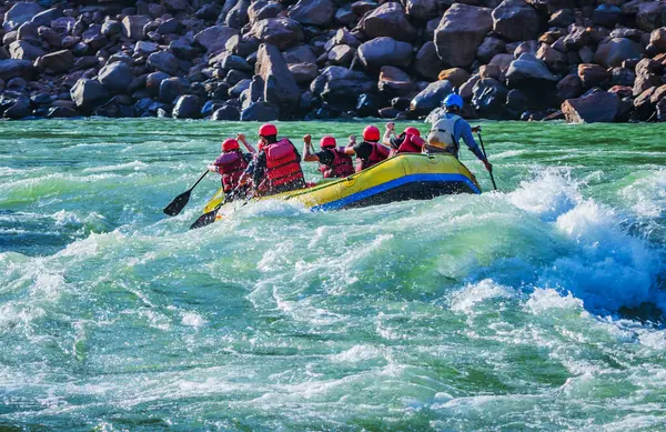 İnsanlar Rishikesh Hindistan 'da Ganj nehrinde rafting yaparken eğleniyorlar.