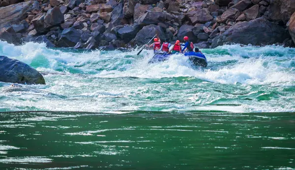 İnsanlar Rishikesh Hindistan 'da Ganj nehrinde rafting yaparken eğleniyorlar.