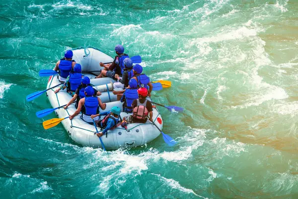 İnsanlar Rishikesh Hindistan 'da Ganj nehrinde rafting yaparken eğleniyorlar.