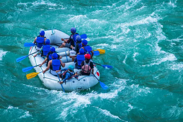 İnsanlar Rishikesh Hindistan 'da Ganj nehrinde rafting yaparken eğleniyorlar.