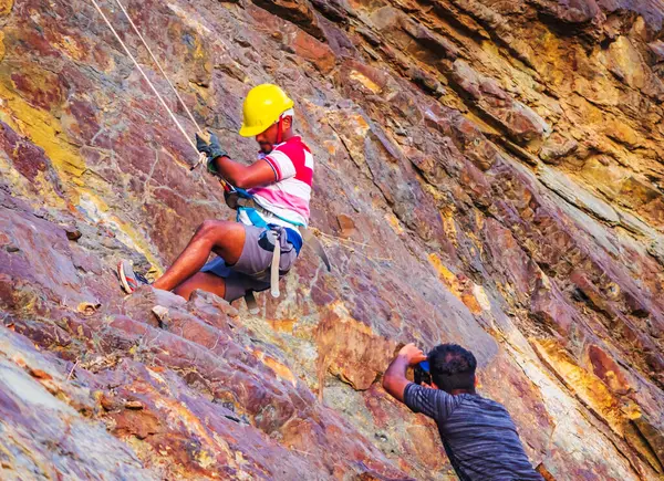 Genç dağcı Rishikesh Hindistan 'da kaya tırmanışı yapıyor.