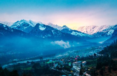 Himalayalar 'ın güzel manzarası ve Himachal Hindistan' da günbatımında bulutlarla kaplı Manali şehri.