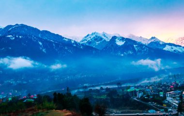 Himalayalar 'ın güzel manzarası ve Himachal Hindistan' da günbatımında bulutlarla kaplı Manali şehri.