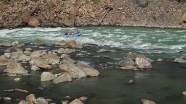 İnsanlar Rishikesh, Hindistan 'daki Ganj Nehri' nde rafting yapmaktan keyif alıyor.
