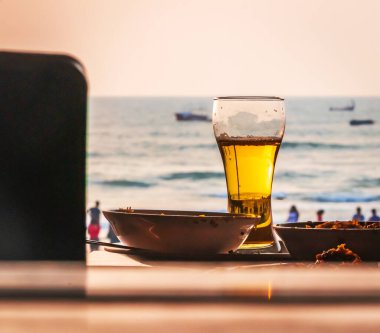 Okyanus Goa üzerinde gün batımında serinletici bira, Hindistan