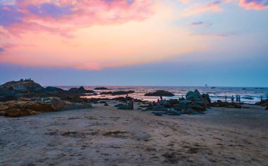 Huzurlu Kıyı Sahnesi İnsanların Sunset Vagator Sahili, Goa, Hindistan 'da Kayalıklarda Rahatladıkları