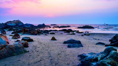 Huzurlu Kıyı Sahnesi İnsanların Sunset Vagator Sahili, Goa, Hindistan 'da Kayalıklarda Rahatladıkları