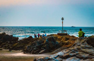 Huzurlu Kıyı Sahnesi İnsanların Sunset Vagator Sahili, Goa, Hindistan 'da Kayalıklarda Rahatladıkları