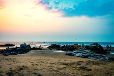 Huzurlu Kıyı Sahnesi İnsanların Sunset Vagator Sahili, Goa, Hindistan 'da Kayalıklarda Rahatladıkları