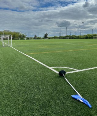 Empty Soccer Field with Corner Flag and Cloudy Sky in Milton Keynes, UK