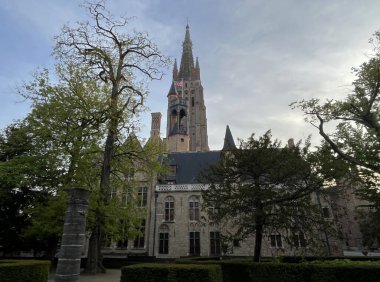 Bahar akşamları parktan Lady Manzarası Kilisesi, Brugge, Belçika, antik ortaçağ binası, ünlü turistik mekan, popüler şehir simgesi, posta kartı veya poster konsepti.