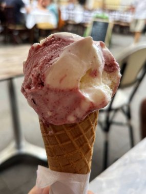 Waffle külahında el ele dondurma kepçesi, tatlı tatlı vanilyalı yaz tatlısı, dikey nesne yakın plan, bulanık arka plan karşısında seçici odak noktası