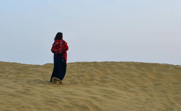 Woman standing on Thar Desert in Jaisalmer, India. Thar Desert is a large arid region in the northwestern part of the Indian.