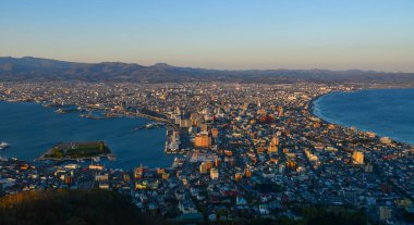 Hakodate, Japonya - 27 Nisan 2023. Japon Hakodate Dağı 'nın tepesinden gün batımında liman şehrinin manzarası.