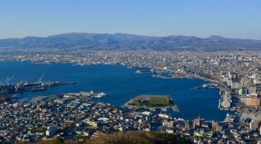 Hakodate, Japonya - 27 Nisan 2023. Japon Hakodate Dağı 'nın tepesinden gün batımında liman şehrinin manzarası.