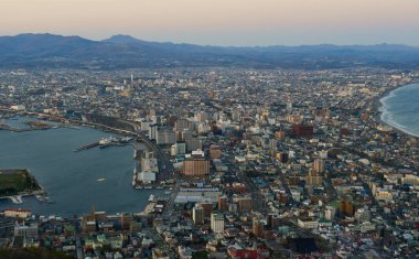 Hakodate, Japonya - 27 Nisan 2023. Japon Hakodate Dağı 'nın tepesinden gün batımında liman şehrinin manzarası.