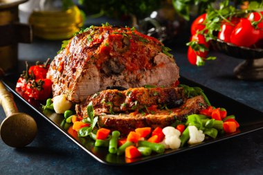 Tam kavrulmuş, domates, zeytin ve domuz boynuyla doldurulmuş. Karanlık arka plan, karanlık ruh hali.