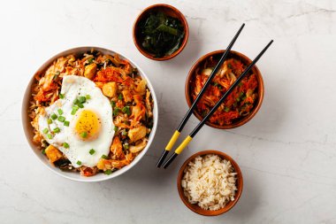 Pirinç ve tavuklu kimçi lahanası. Hafif mermer arka planda beyaz bir kasede servis edilmiş. Üst görünüm.